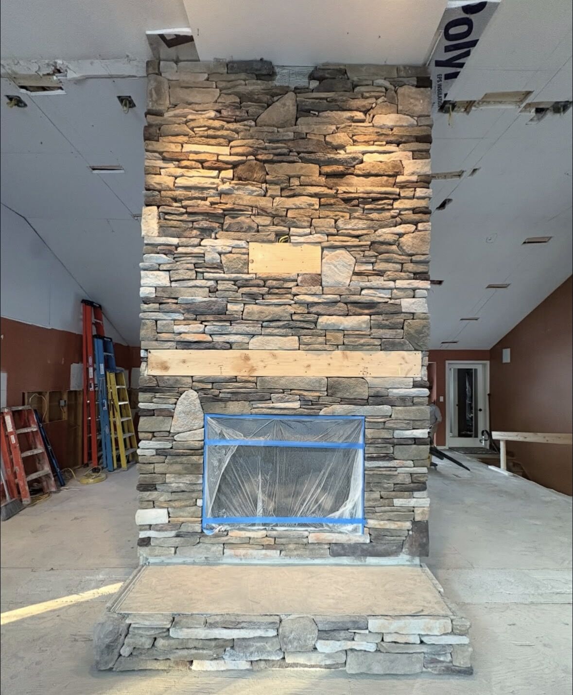 Floor-to-ceiling stone fireplace built by MST Construction